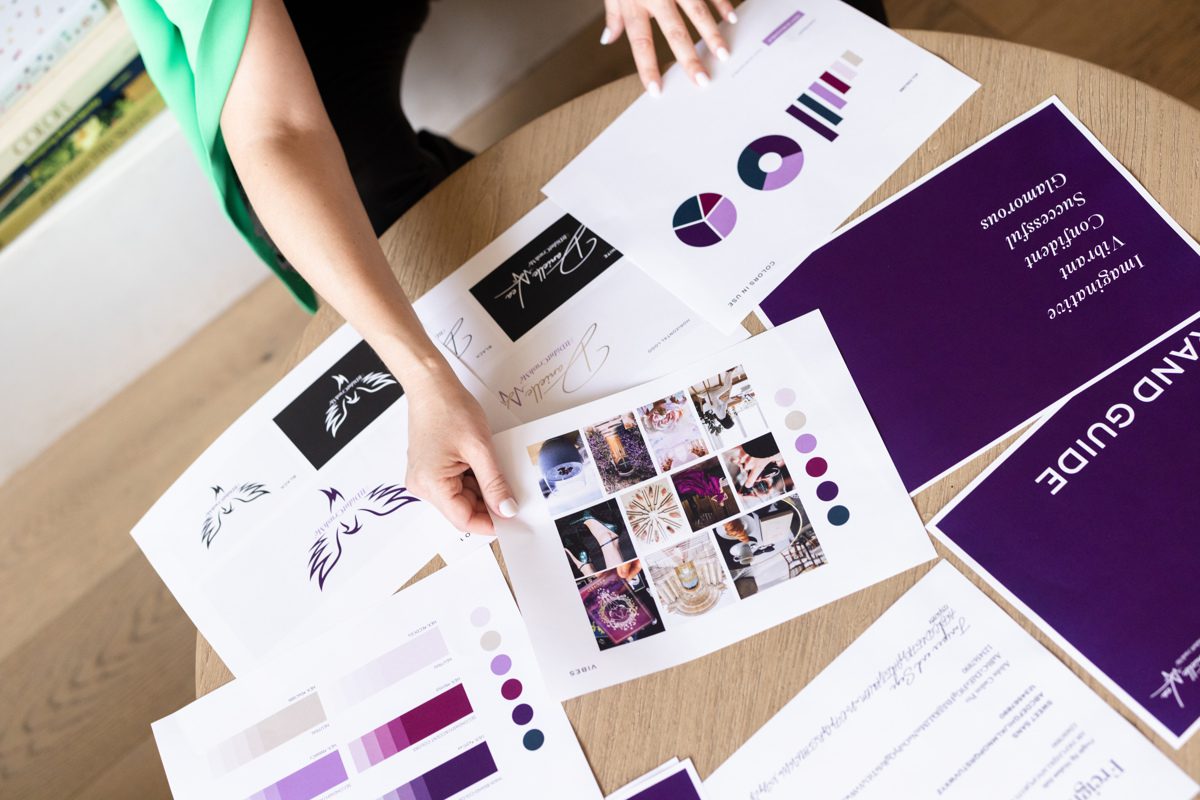 Pages of a brand guide spread out on a coffee table